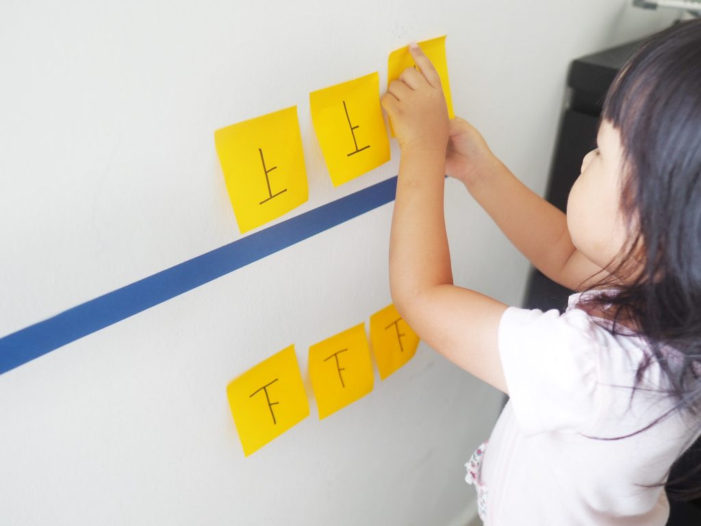 Children playing with post-its and learning chinese