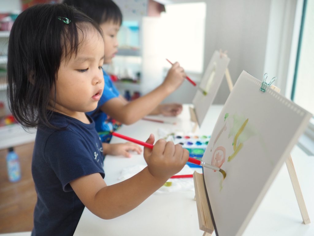 Children painting on easel
